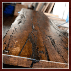 Close-up of a rustic wooden table with visible grain and metal accents.