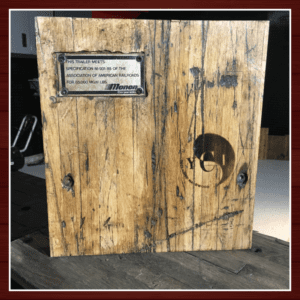 A rustic wooden box with a metal plaque and a circular design.