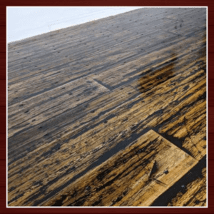 Close-up of textured wooden floorboards with varying shades and grain patterns.