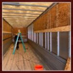 Truck interior with ladder and construction materials.